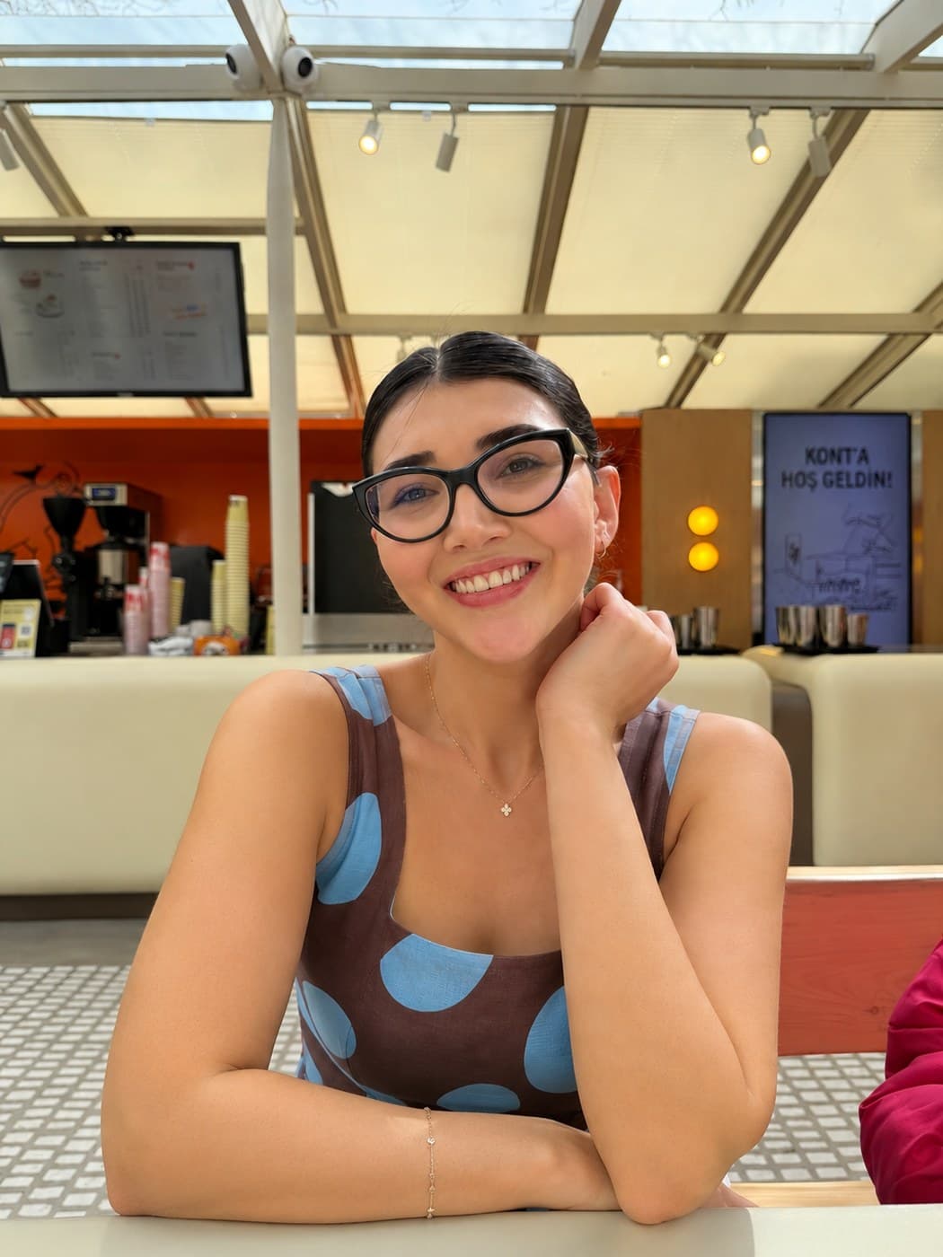 Tuba Baytekin bir kafede, gülümserken